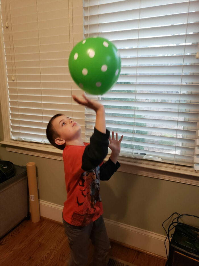 child playing balloon bounce at home