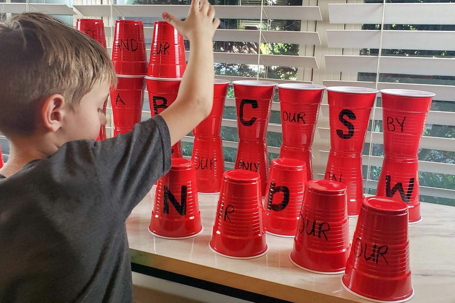 Redeemer of Israel Cup Stacking singing time ideas for LDS Primary Music Leaders. The kids will absolutely love stacking cups in a tall castle wall or pyramid as they learn this beloved Hymn with a crack the code hidden in!