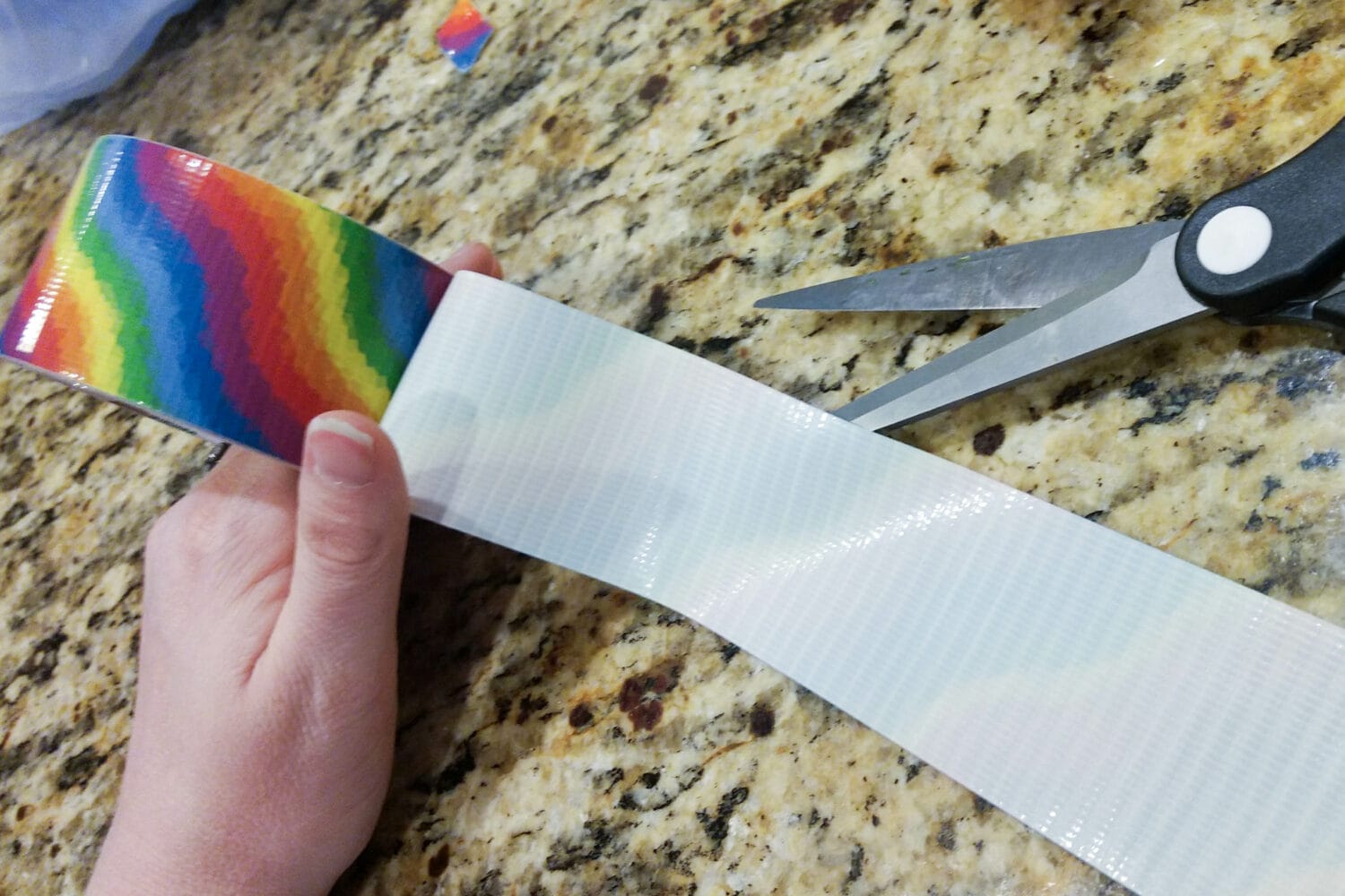 cutting colorful duct tape in half width wise to make 1" wide duct tape