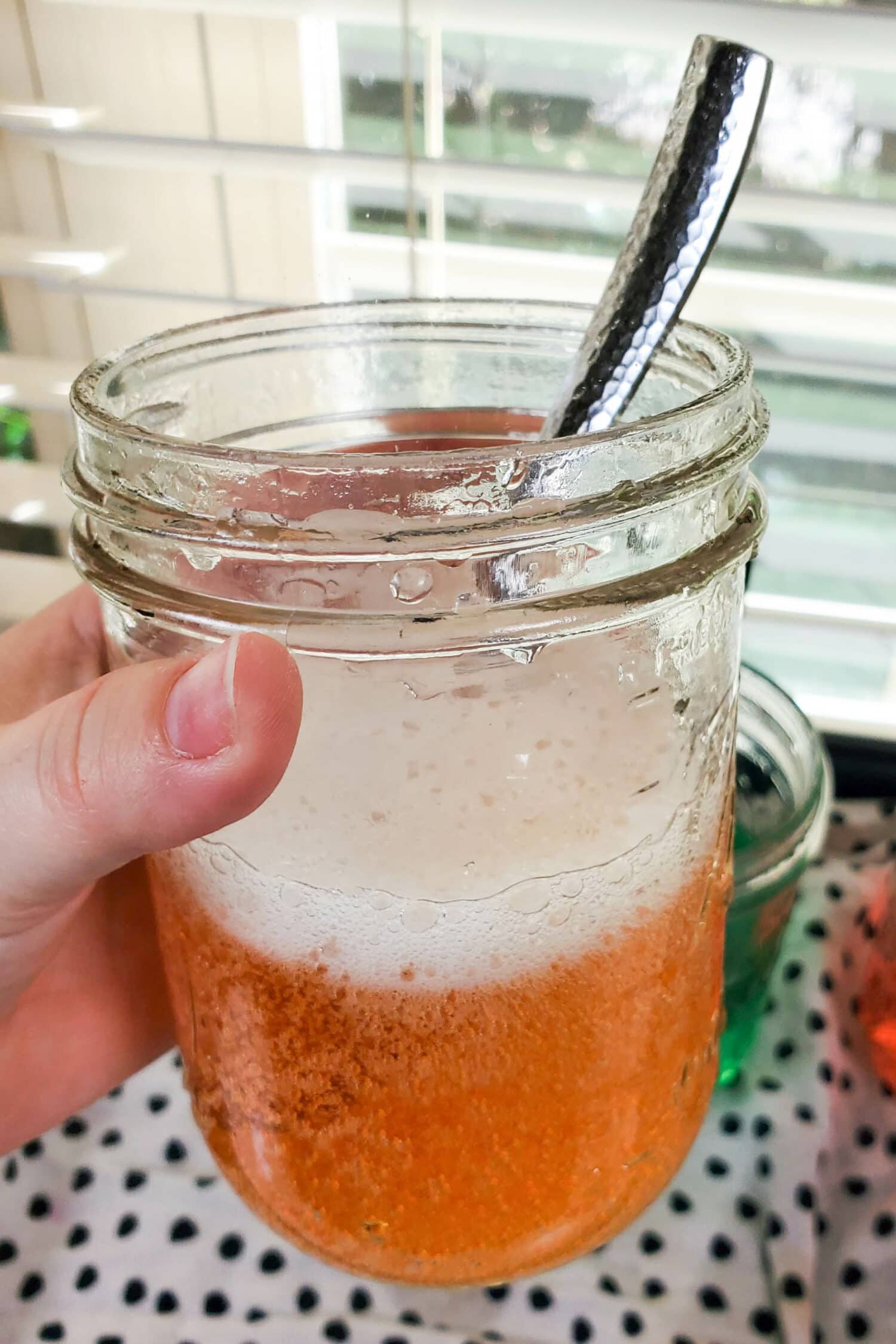 Orange magic potion almost finished fizzing in a glass mason jar easy to follow tutorial for how to make a magic potion